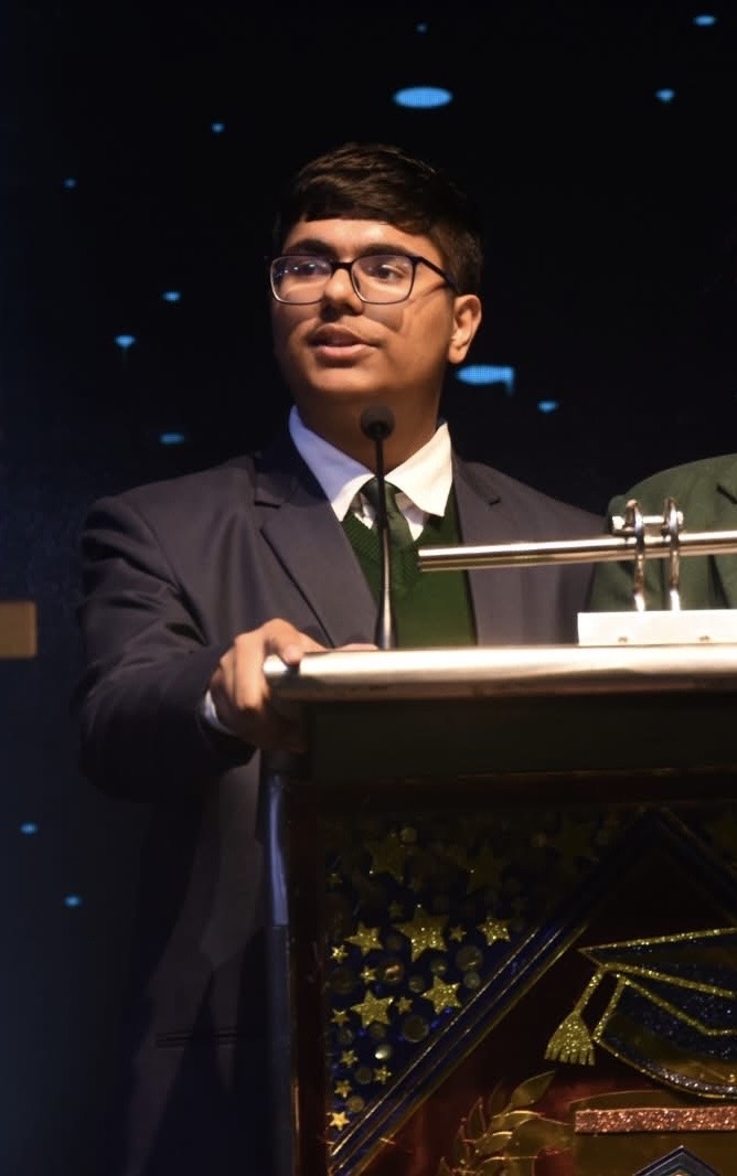 Ikshit Sethi speaking at a podium